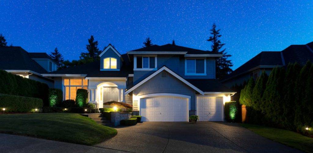 Suburban Home During Late Evening Well Lit By Security Lighting